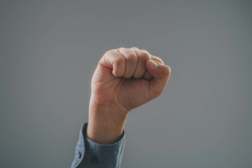 Close-up of a raised fist symbolizing strength, determination, and unity against challenges in a...