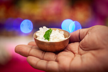 An Indian man offers a bowl of 'Maakhan Misri' to Laddu Gopal, a Hindu god, Krishna, during the...