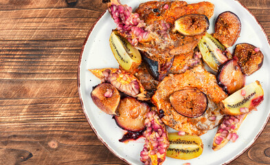 Grilled pork chops with kiwi and pomegranate.