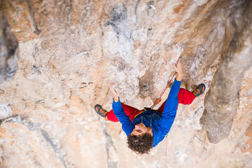 A rock climber ascends to the summit via a difficult route.