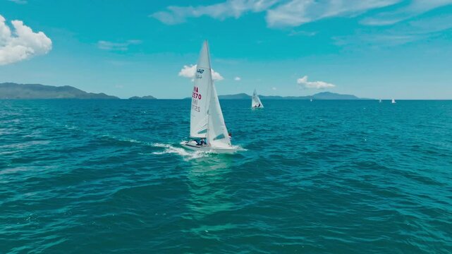 Sailors are having fun using a small sailboat at sea