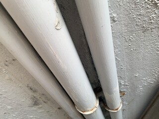 pipe and pipes on white old cement wall
