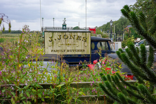 Vintage Jack Jones famous butcher truck dads army, parked in a scenic countryside field.