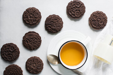 Overhead view of stamped chocolate cookies on a parchment lined baking tray, top view of embossed chocolate sugar cookies on a white background