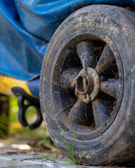 Close-up of dirty rubber wheel of garden equipment.