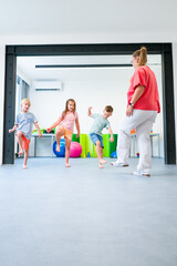 Young children exercising with physical therapist during group therapy session. Child occupational...