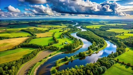 Fototapeta premium Aerial view of a meandering river, surrounded by lush green forests, winding roads, and rural farmland, under a clear blue sky with fluffy white clouds.