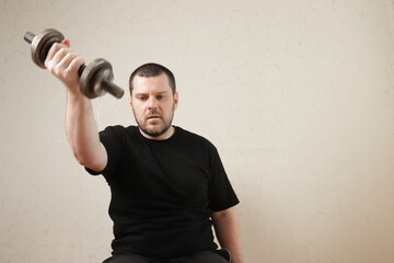 Man exercising in home gym, practicing strength training with dumbbells, enhancing his muscular...