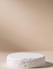 Empty round podium for product presentation, minimal pedestal. Light beige backdrop.