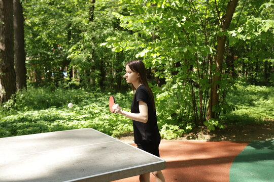 Ping pong player, participating in a competitive match, playing table tennis at a club with friends.