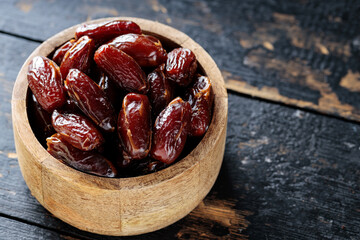 Dried Dates in Wooden Bowl on Dark Rustic Background, Copy Space