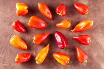 Colorful Bell Peppers Scattered on Rustic Brown Background, Top View