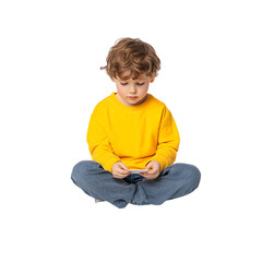A young boy in a yellow shirt sitting cross-legged and focused