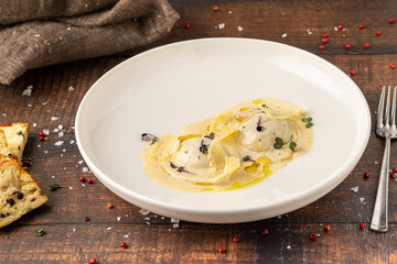 Cheese ravioli with sauces on a white porcelain plate