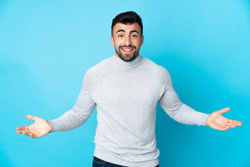 Caucasian man over isolated blue background happy and smiling