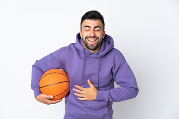 Obraz premium Man playing basketball over isolated white wall smiling a lot