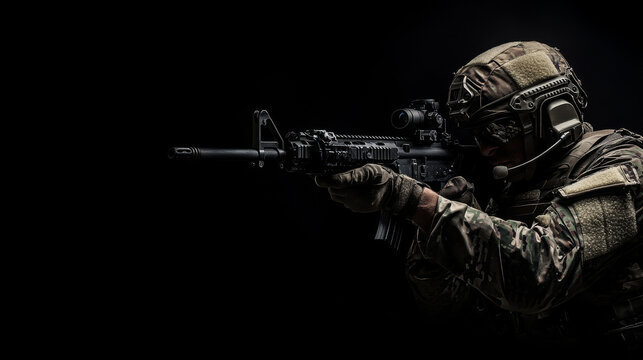Special forces soldier holding a rifle on a black background. 