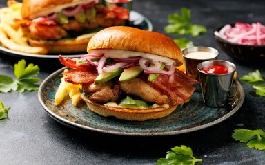 Chicken sandwich, burger with bacon, pickled onion, avocado, mayonnaise and french fries