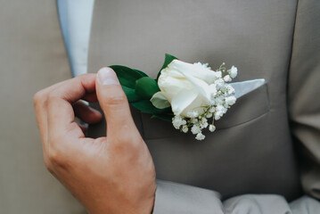 Men dressing up before the party with flower corsage details