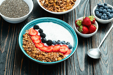 Healthy breakfast . Yogurt with berries ( strawberry , raspberry , blueberry , blackberry ) , granola and chia seeds . Top view