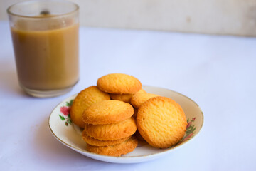 breakfast menu in the form of Danish butter cake and a glass of chocolate milk, Close up of butter cookies coated with white sugar and a glass of chocolate, sweet cake