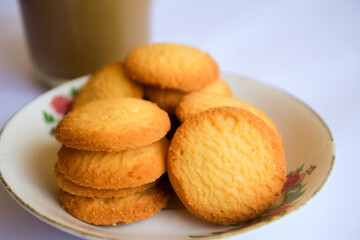 breakfast menu in the form of Danish butter cake and a glass of chocolate milk, Close up of butter cookies coated with white sugar and a glass of chocolate, sweet cake