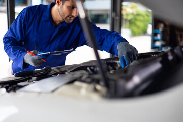 Close up hand hispanic latin male mechanic repairs car in garage. Closeup hand. Auto car mechanic...