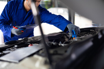 Close up hand hispanic latin male mechanic repairs car in garage. Closeup hand. Auto car mechanic checking the oil level of the car engine. Car repair and maintenance