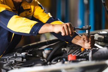 Close up mechanical hand with tools and spanner. Hispanic latin male mechanic repairs car in...