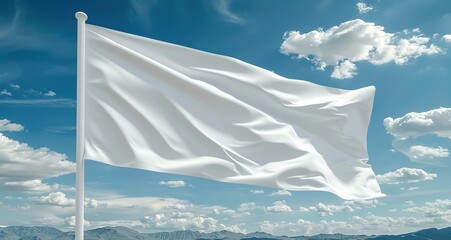 White flag waving in the wind against a blue sky with clouds. Symbolic of peace, surrender, or a blank canvas.