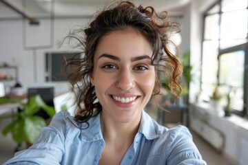 Obraz premium Closeup portrait of a happy young woman in an office taking a selfie