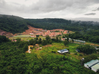 Aerial shot in the outskirts of Le Bat, Phu Quoc, Vietnam. A small military complex in can be seen in the middle of the Vietnamese rainforest