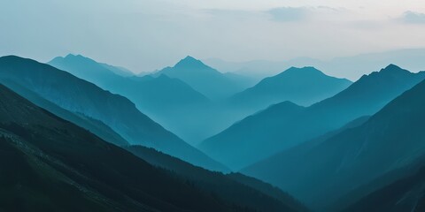 Fototapeta premium Serene mountain landscape with layered peaks shrouded in mist, creating a peaceful and tranquil atmosphere in the wilderness.