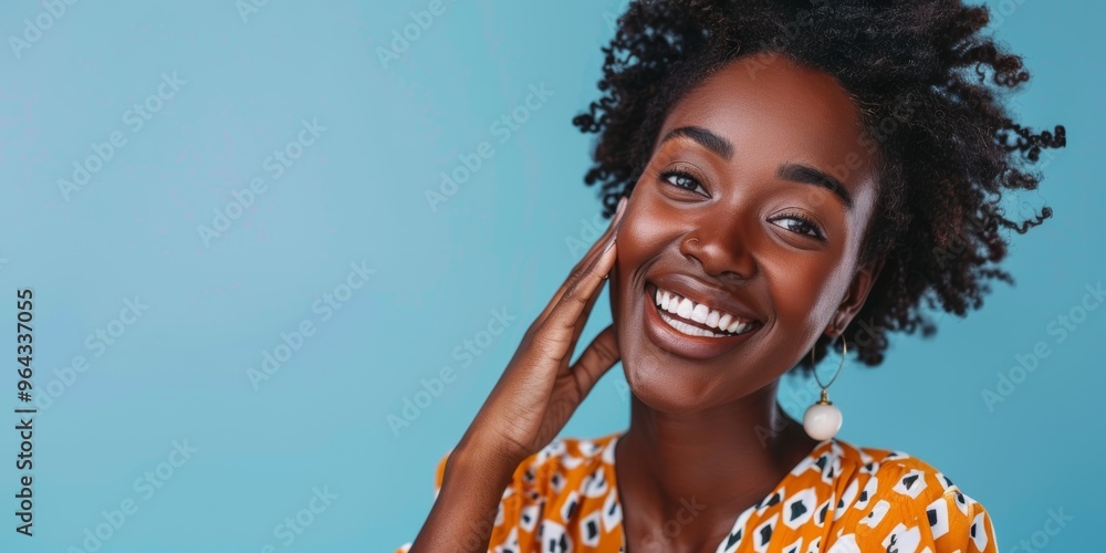 Poster Portrait of a woman smiling and signaling communication in a studio with a blue background. Joyful model demonstrating mobile chat or conversation gestures