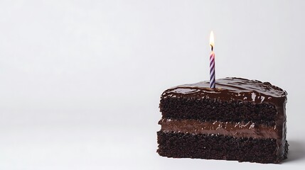 A close-up of a chocolate cake slice with a candle, set against an unblemished white background.