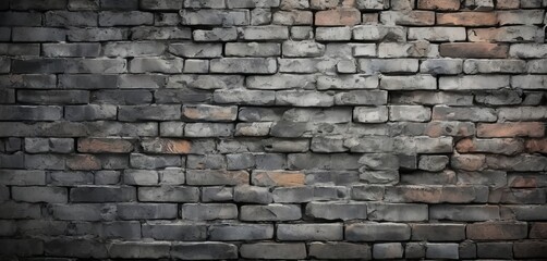 Fototapeta premium a close-up view of a brick wall, with the bricks varying in shades of gray and brown. The bricks are arranged in a uniform pattern, creating a textured and weathered appearance.