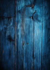 a close-up view of a weathered wooden surface with a dark blue hue, featuring visible cracks and knots in the wood grain.