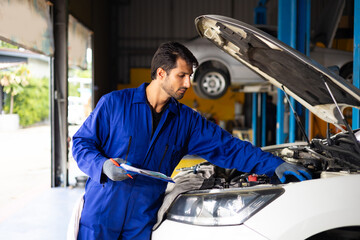 Hispanic latin man mechanic repairs car in garage. Car maintenance and auto service garage concept. Closeup hand and spanner. Insurance agent