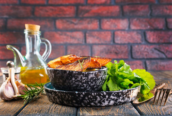 Bowl with baked potatoes on wooden background