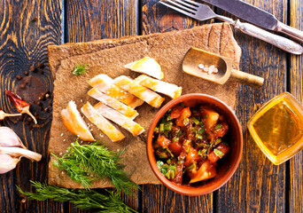 chicken fillet on board with vegetable stew in bowl
