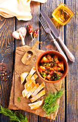 chicken fillet on board with vegetable stew in bowl