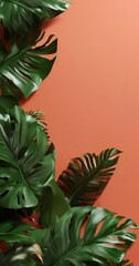 Fototapeta premium close-up view of lush, green monstera leaves against a vibrant orange background.