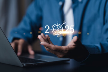 Set goals for 2025. Businessman holds 2025 text with business operations goals. To achieve the...
