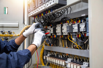 Checking the electrical system, an electrician is using an electric meter to check the electrical...