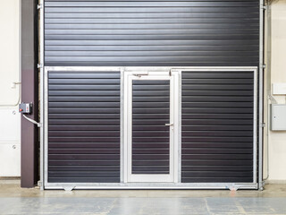 Rolling hangar door. Gate on wall of industrial building. Industrial roller shutters view from inside. Automatic roller shutters. Exit from industrial hangar. Roller shutter gate for factory