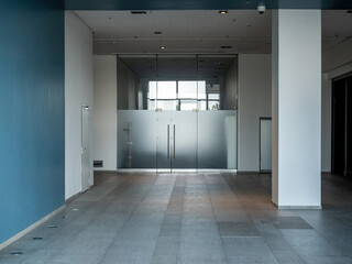 Interior of entrance group of business center. Office building from inside. Glass doors to office in business center. Entrance to meeting room with tinted glass. Office building corridor with doors
