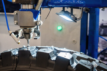 Production winter tires. Process adding studs to car wheels. Production rubber for driving on slippery roads. Automotive industry. Apparatus inserting rivets onto tire. Manufacturing car wheels