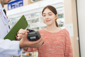Customer woman paying by credit with NFC technology, holding credit card over terminal screen. Hand of customer using credit card over payment machine. Pay by credit card. Pay online concept