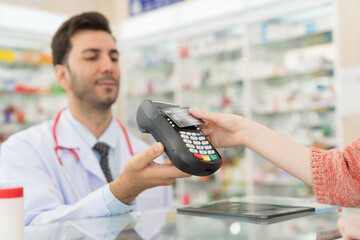 Customer woman paying by credit with NFC technology, holding credit card over terminal screen. Hand of customer using credit card over payment machine. Pay by credit card. Pay online concept