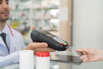 Customer woman paying by credit with NFC technology, holding credit card with terminal screen. Hand of customer using credit card with payment machine. Pay by credit card. Pay online concept